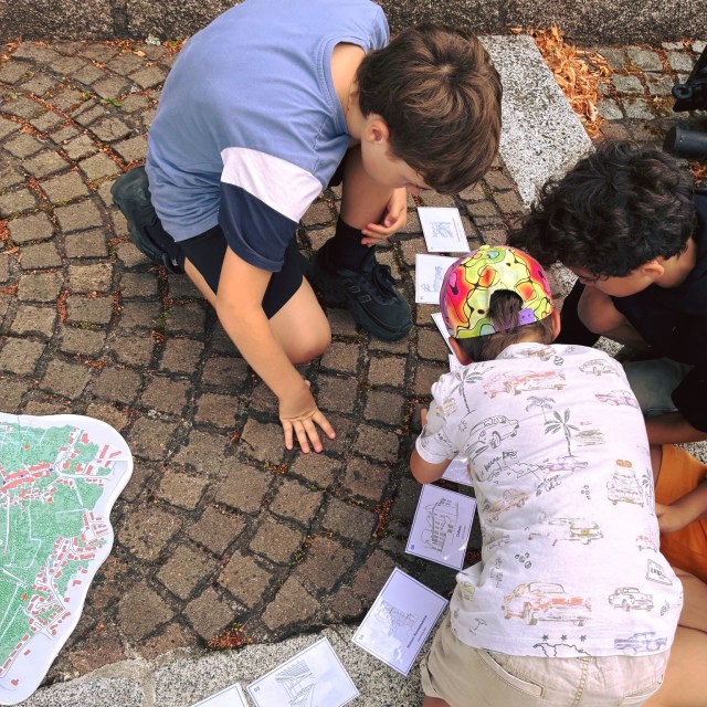 Retour sur la semaine 2 – du 27 au 31 juilletDans le cadre du dispositif « Patrimoine en partage » du ministère de la Culture, Heruditatem s'est associée au service Patrimoine de la Ville de Vandœuvre-lès-Nancy et à la MJC Lorraine pour deux semaines de stages dédiées à la découverte du patrimoine.Une quarantaine d'enfants ont exploré le patrimoine de Vandœuvre-lès-Nancy Village à travers un programme mêlant découverte, expérimentation et création.Au programme de cette première semaine :• un jeu de piste dans le village pour observer et comprendre le territoire ;• des ateliers de maquettes autour de la thématique du patrimoine bâti ;• une journée de découverte du patrimoine de la ville de Toul, afin d'ouvrir le regard sur un autre territoire.Une semaine riche en observations, en échanges et en créations pour découvrir le patrimoine autrement.